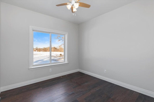 spare room featuring visible vents, baseboards, ceiling fan, and dark wood-style flooring