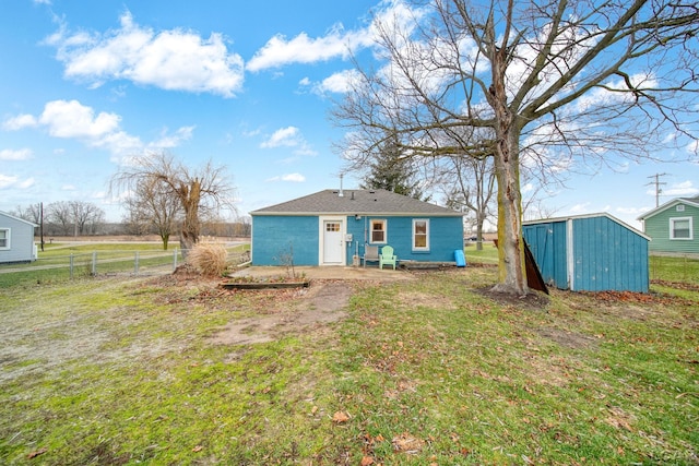 back of house with a lawn and a storage shed