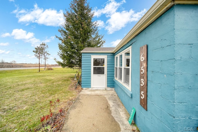 entrance to property featuring a lawn