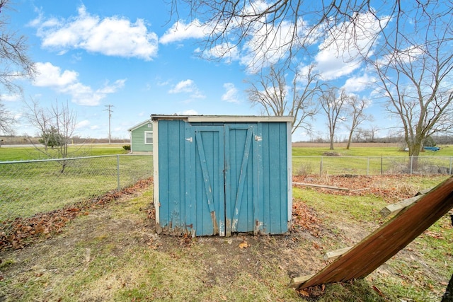 view of outbuilding with a lawn and a rural view