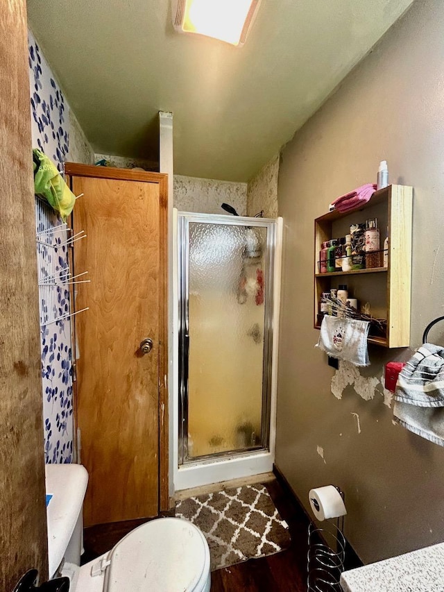 bathroom with toilet and a shower with shower door