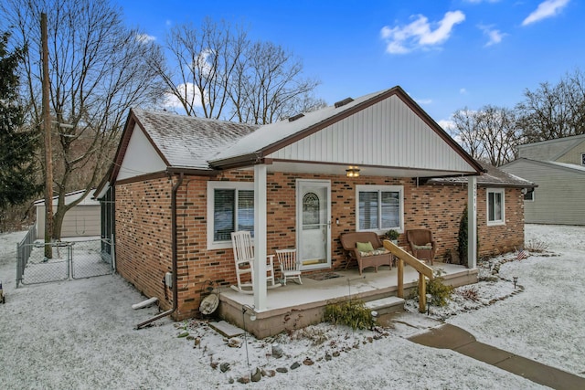 view of front of property featuring a garage, covered porch, and an outbuilding