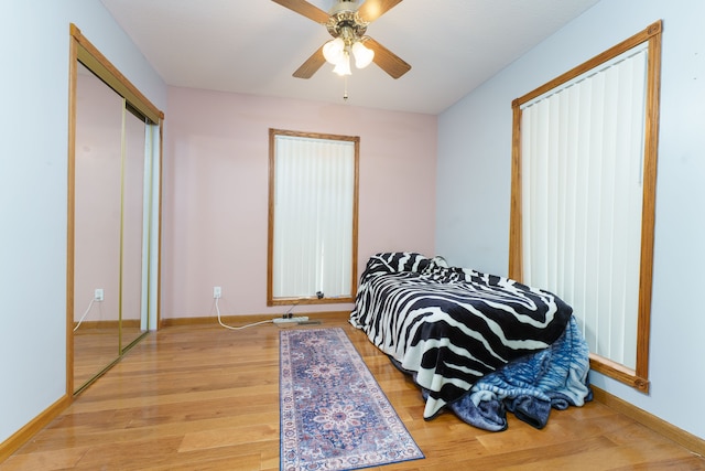 bedroom featuring ceiling fan, light hardwood / wood-style floors, and a closet