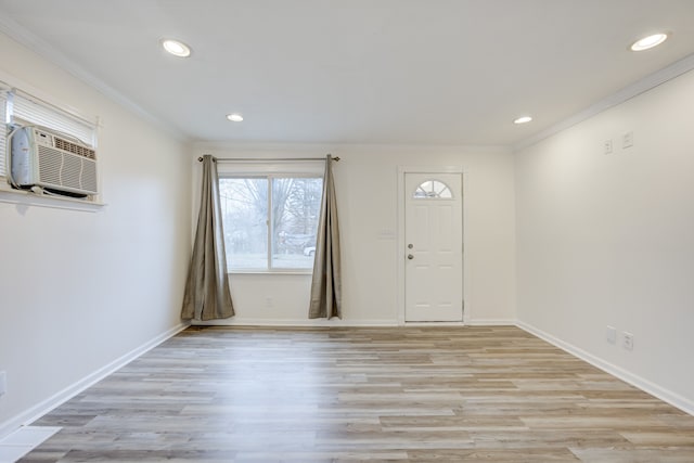 foyer featuring crown molding, a wall mounted AC, and light hardwood / wood-style flooring