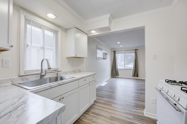 kitchen featuring white cabinetry, sink, light hardwood / wood-style flooring, white range, and ornamental molding