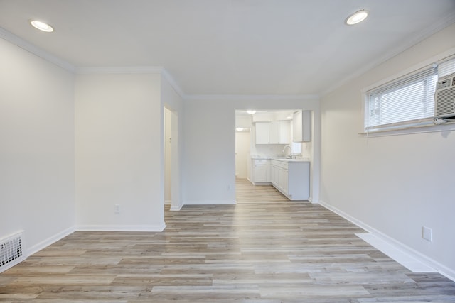 unfurnished living room with light hardwood / wood-style flooring, ornamental molding, and sink