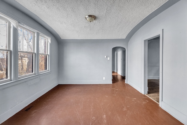 empty room featuring lofted ceiling and a textured ceiling