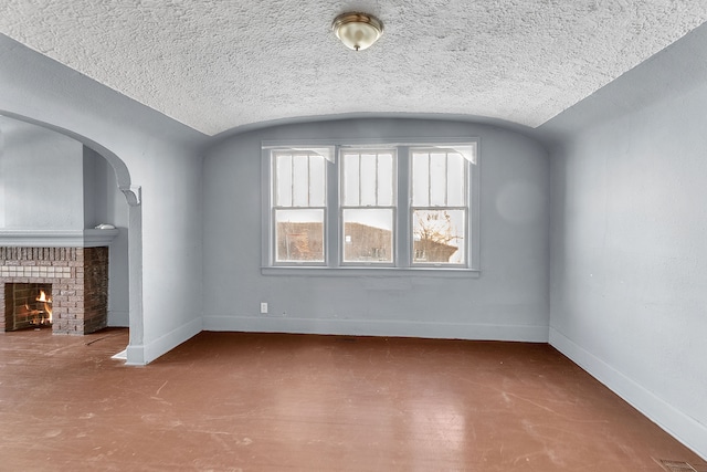 unfurnished living room featuring vaulted ceiling and a brick fireplace