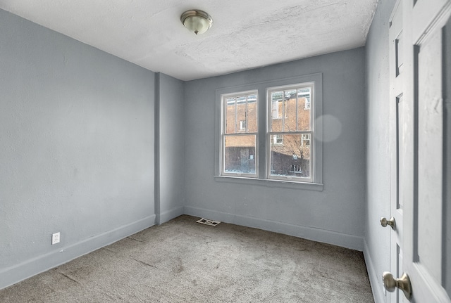 unfurnished room with carpet floors and a textured ceiling