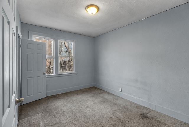 carpeted spare room with a textured ceiling