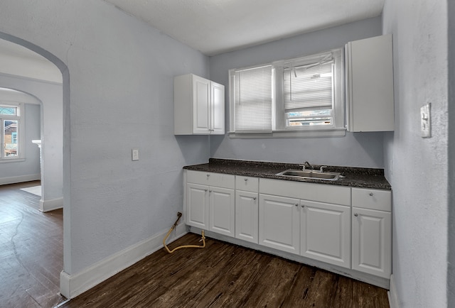 kitchen featuring dark hardwood / wood-style flooring, white cabinetry, and sink