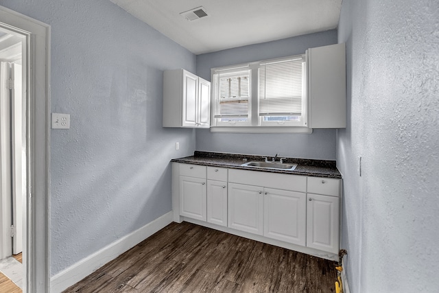 kitchen with white cabinets, sink, and dark wood-type flooring