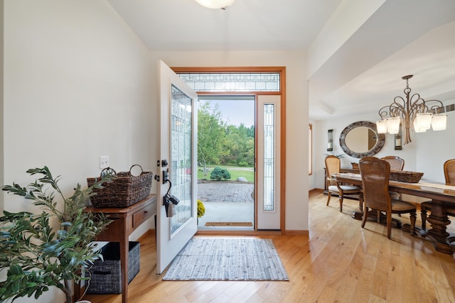 entrance foyer featuring light wood-type flooring and a chandelier