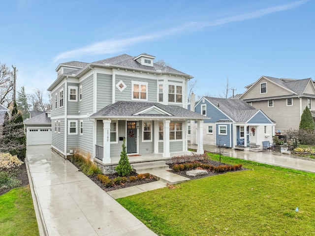 view of front facade featuring an outbuilding, a front lawn, covered porch, and a garage