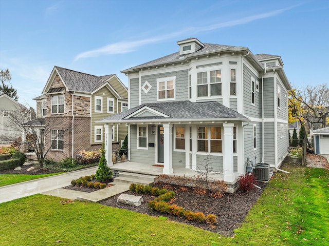 view of front of home featuring a front lawn, cooling unit, and a porch