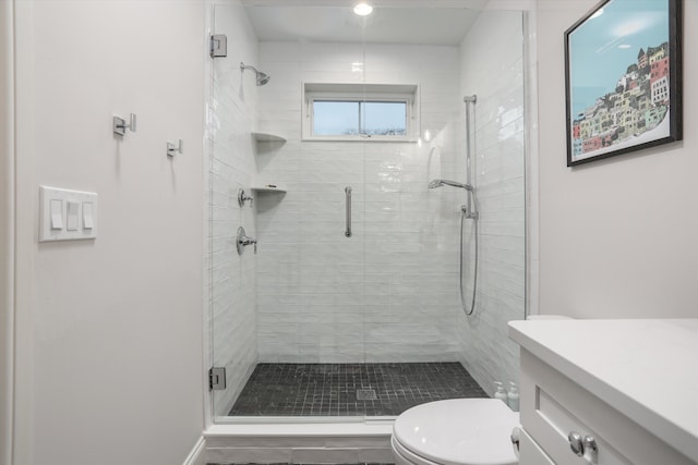 bathroom with a shower with door, vanity, and toilet