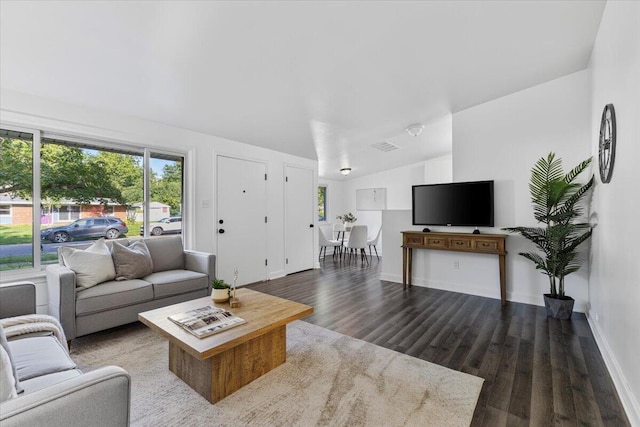 living room featuring dark hardwood / wood-style floors and vaulted ceiling