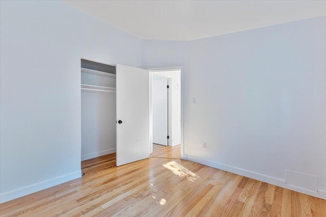 unfurnished bedroom featuring a closet and light wood-type flooring