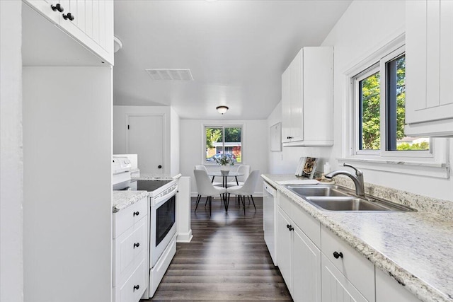 kitchen featuring electric range, sink, stainless steel dishwasher, plenty of natural light, and white cabinets