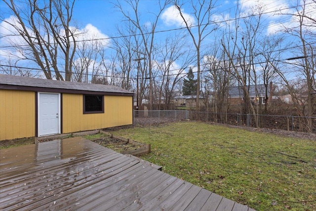 wooden deck featuring a lawn and an outbuilding