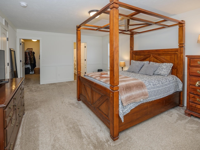 bedroom featuring light carpet and a wainscoted wall