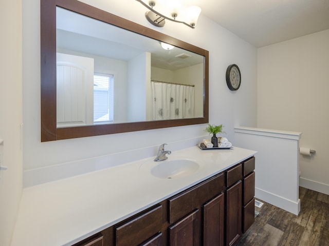 bathroom with vanity, baseboards, and wood finished floors