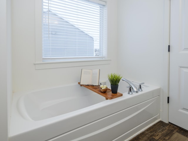 full bath with a garden tub and wood finished floors