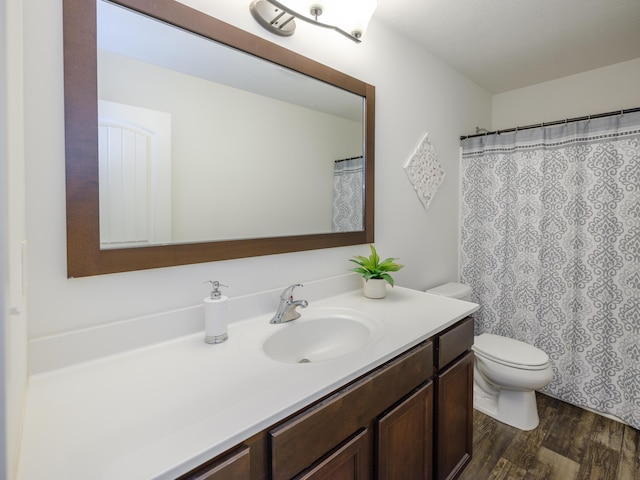 full bath featuring toilet, wood finished floors, and vanity