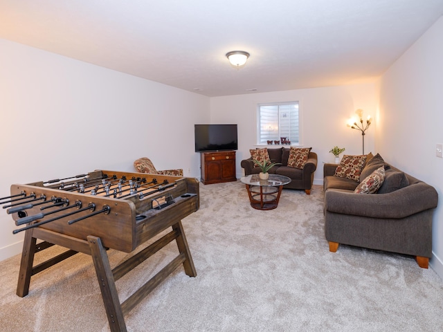 recreation room with light carpet and baseboards