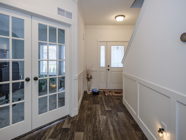 doorway featuring french doors, visible vents, a decorative wall, and dark wood-style flooring