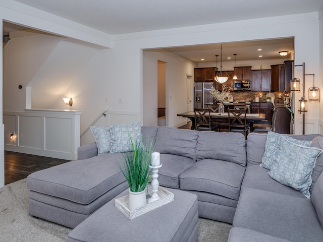 living area with dark wood-type flooring and recessed lighting