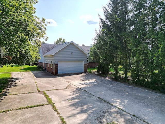 view of side of property featuring a garage and a yard