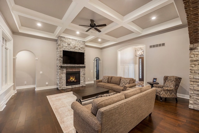 living room featuring a fireplace, dark hardwood / wood-style flooring, and ceiling fan with notable chandelier