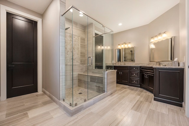 bathroom with vanity and a shower with door