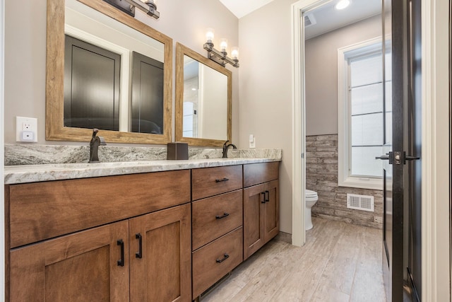 bathroom with hardwood / wood-style floors, vanity, and toilet