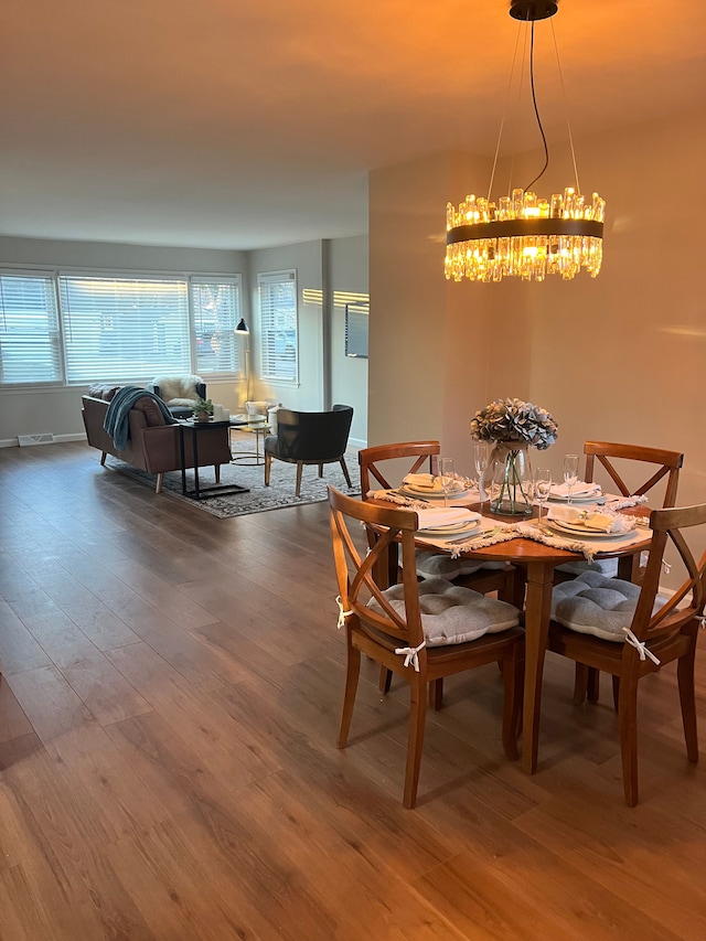 dining area with wood-type flooring and a chandelier