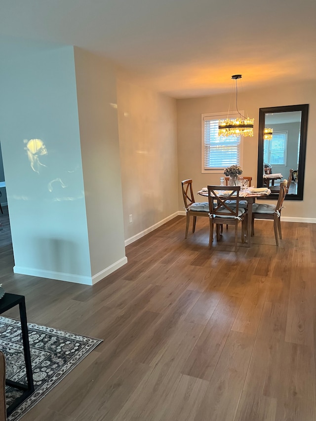 dining space with hardwood / wood-style flooring and a notable chandelier