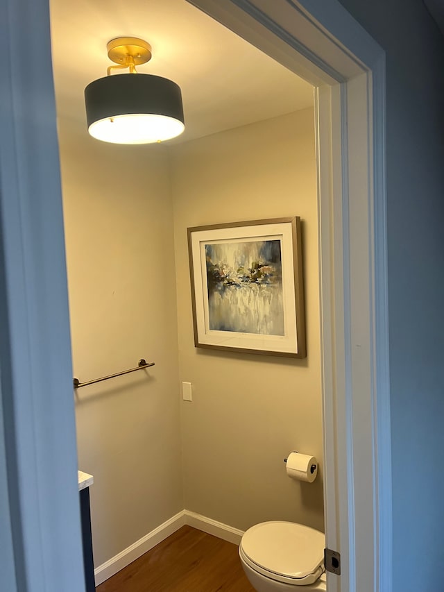 bathroom with hardwood / wood-style flooring and toilet