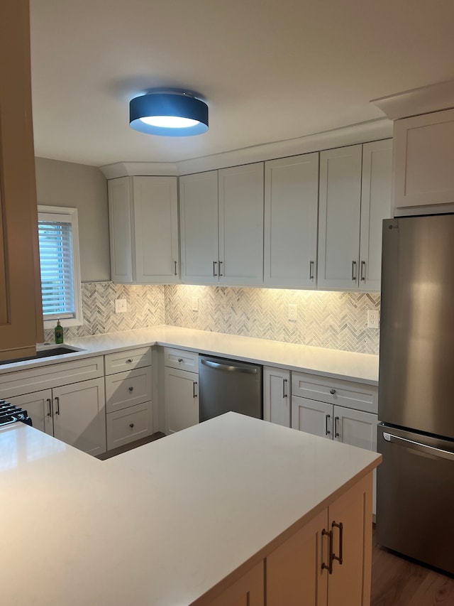 kitchen featuring white cabinetry, appliances with stainless steel finishes, and backsplash