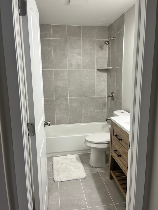 full bathroom with tile patterned floors, vanity, toilet, and tiled shower / bath combo