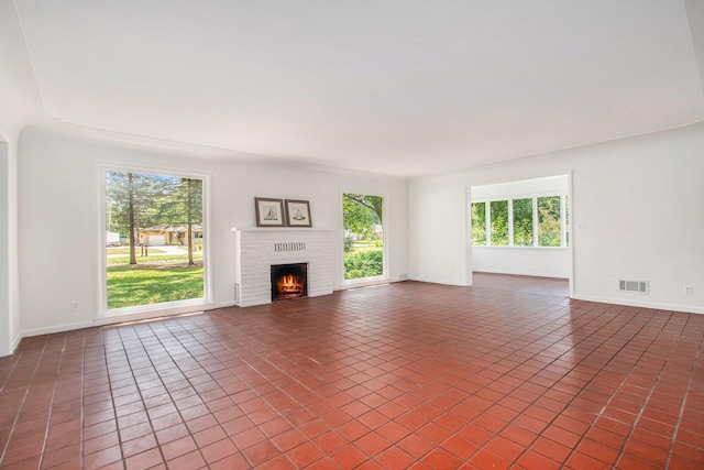 unfurnished living room with dark tile patterned floors and a fireplace