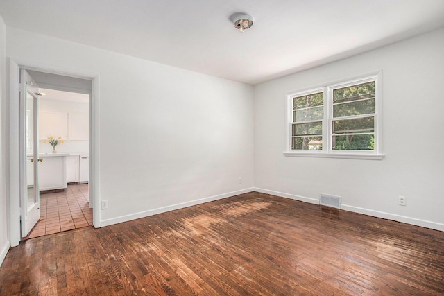 spare room with dark hardwood / wood-style flooring