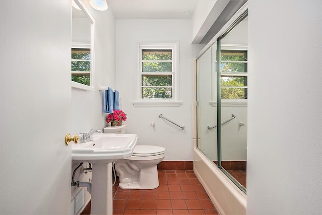 full bathroom with tile patterned floors, sink, bath / shower combo with glass door, and toilet