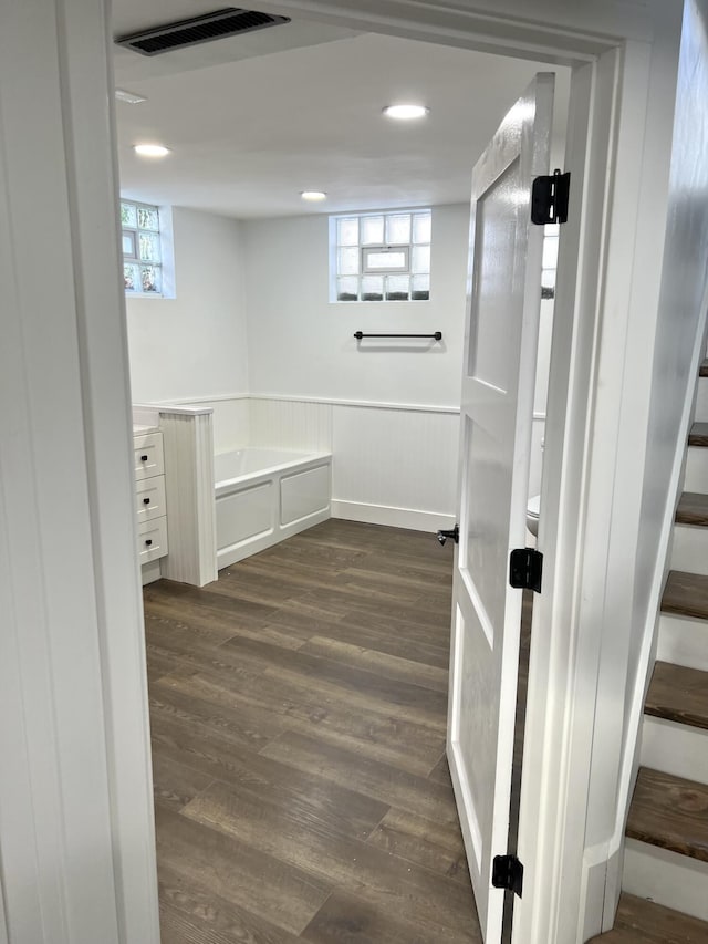 bathroom featuring a washtub, a healthy amount of sunlight, and hardwood / wood-style flooring