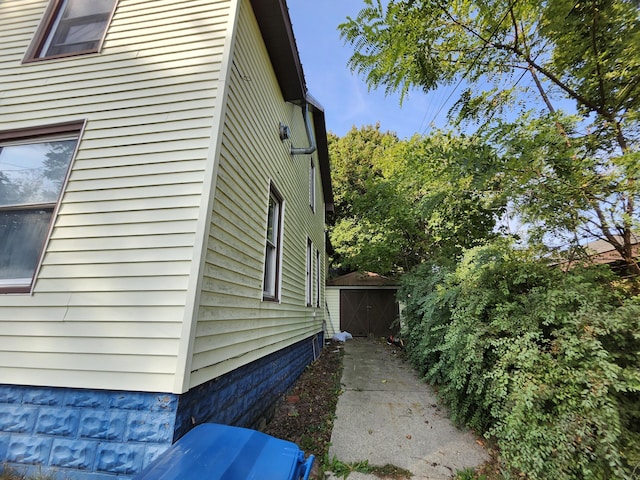 view of side of home featuring a shed