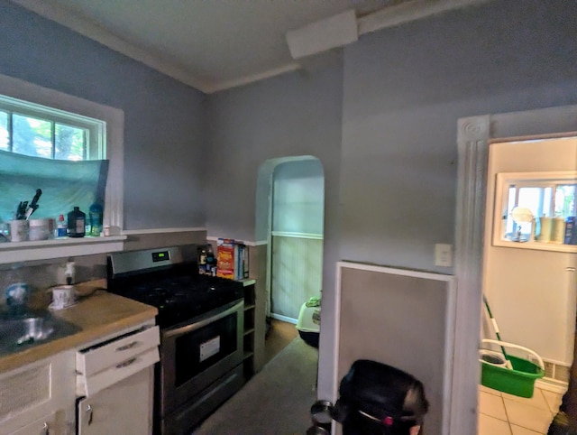 kitchen featuring black range with electric cooktop, white dishwasher, sink, light tile patterned floors, and white cabinets