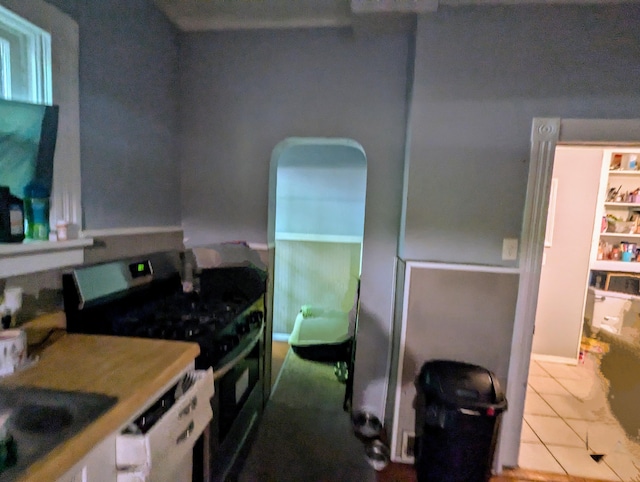 kitchen featuring tile patterned flooring, black range with gas stovetop, dishwasher, and sink