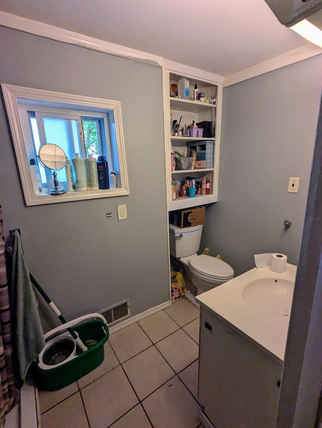 bathroom featuring tile patterned floors, crown molding, vanity, and toilet