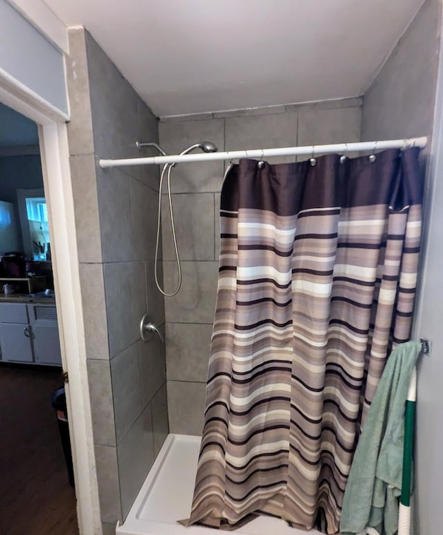 bathroom with hardwood / wood-style floors and a shower with shower curtain