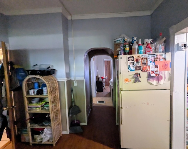 kitchen featuring hardwood / wood-style floors, ornamental molding, and white refrigerator